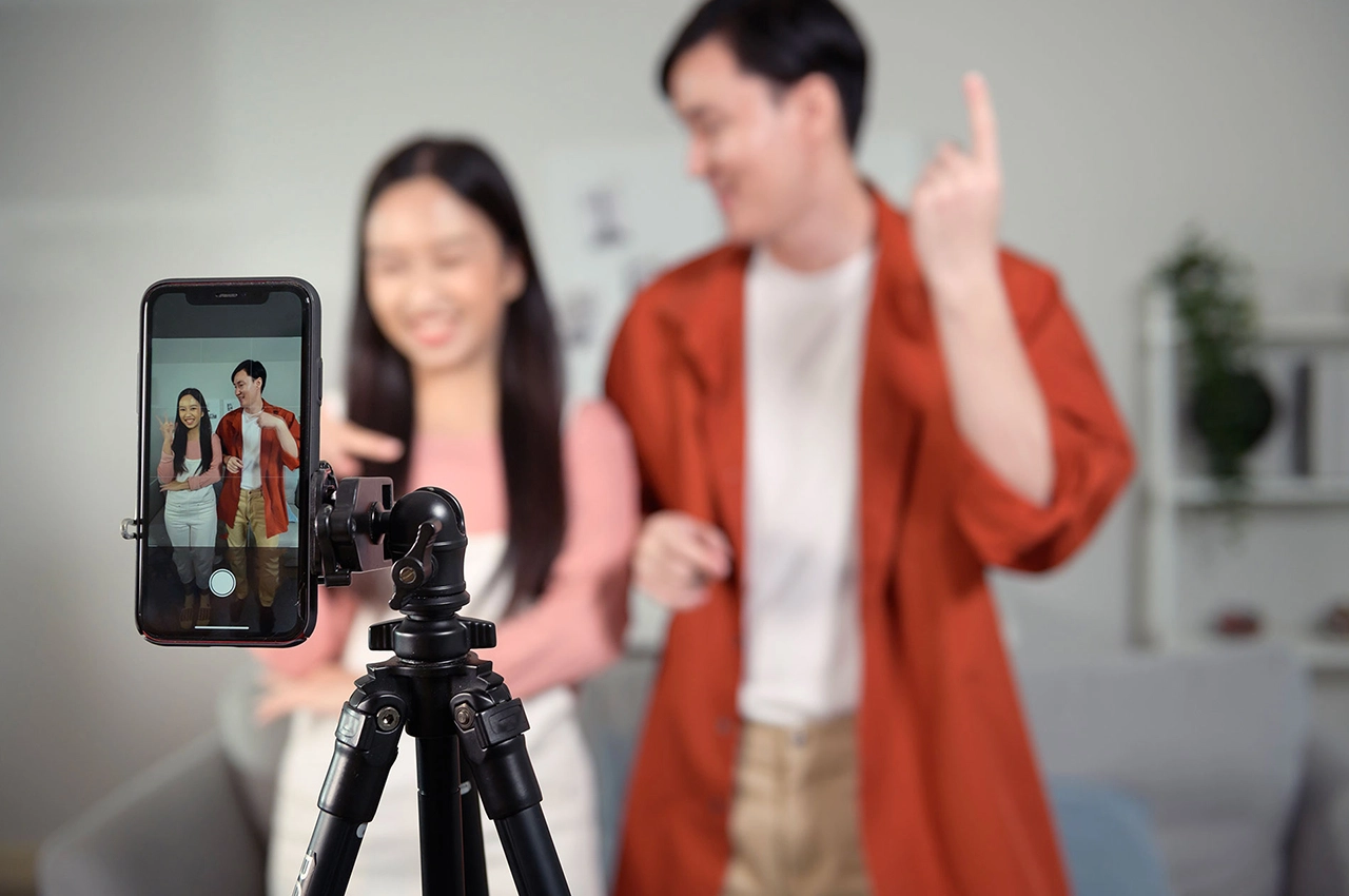 Creator recording a pay-per-video teaser with smartphone on tripod - sell premium videos on Blurbay