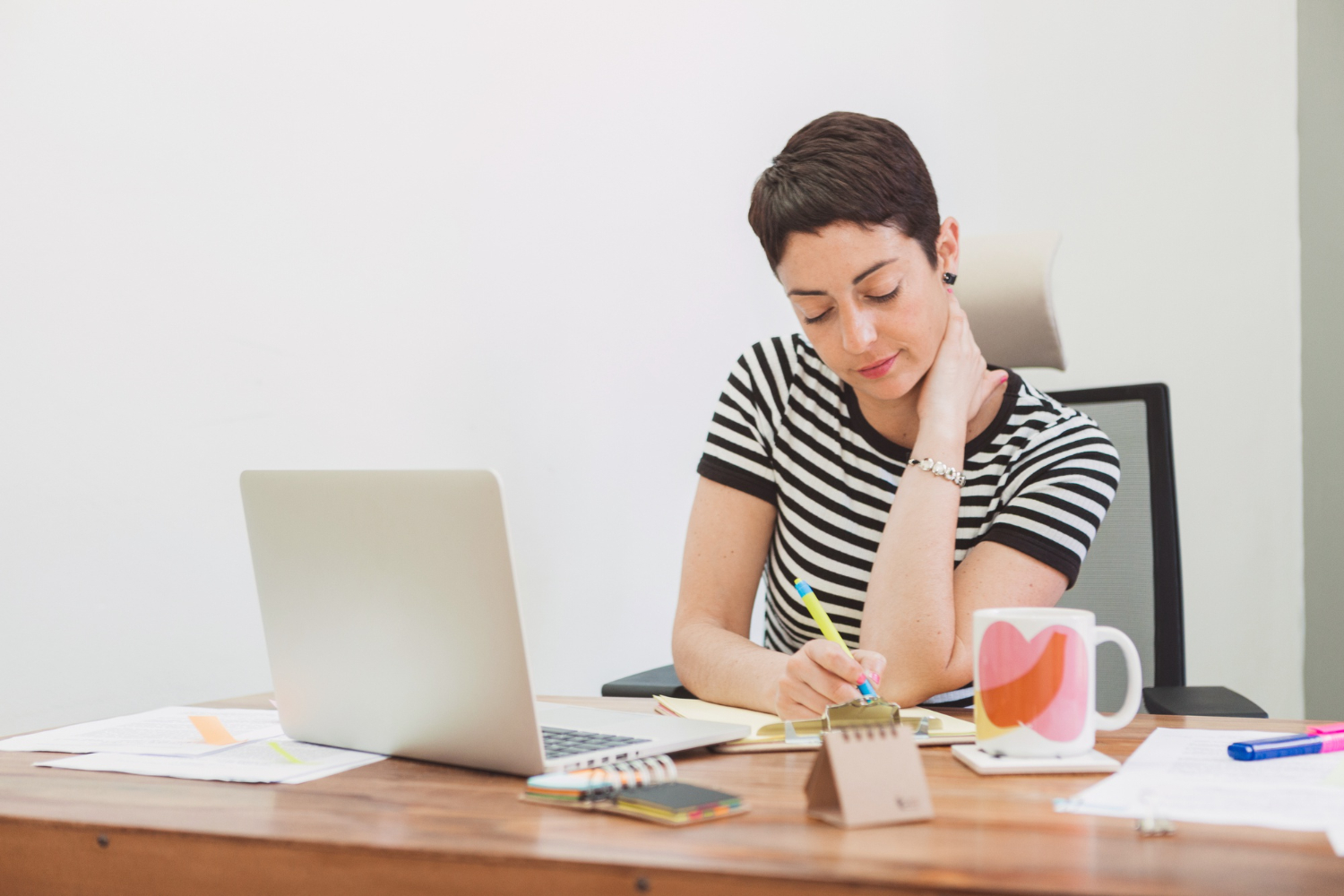 Writer planning monetization strategy at desk with laptop and notebook