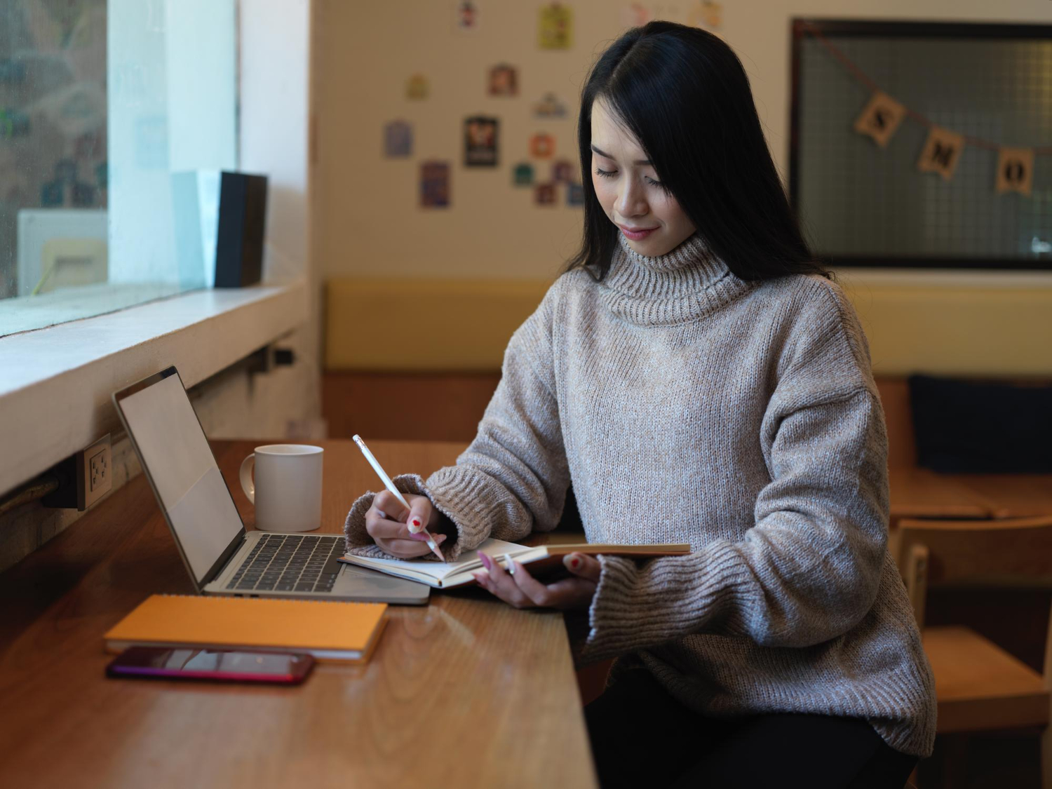 Creator writing an eBook on a laptop at a home workspace